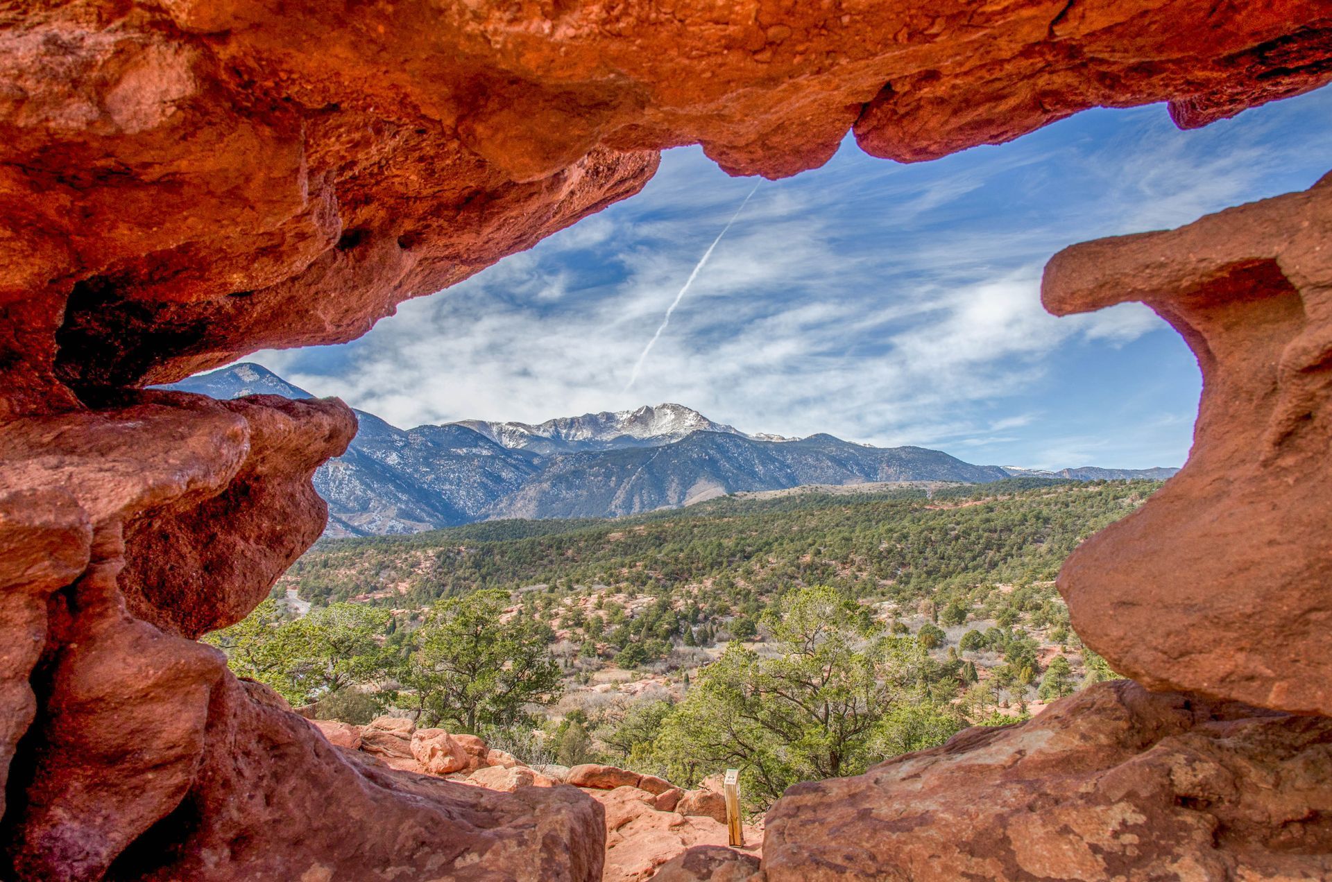 A view of a mountain range through a rock formation.