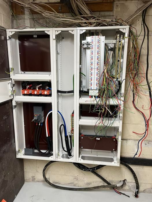 A very messy electrical box with a lot of wires coming out of it.