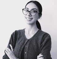 Professional portrait of a woman in a white hijab, smiling.