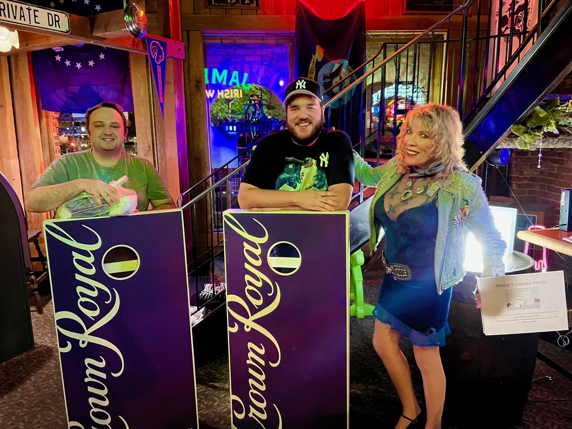 Three women in cowboy hats are sitting at a table in a bar.