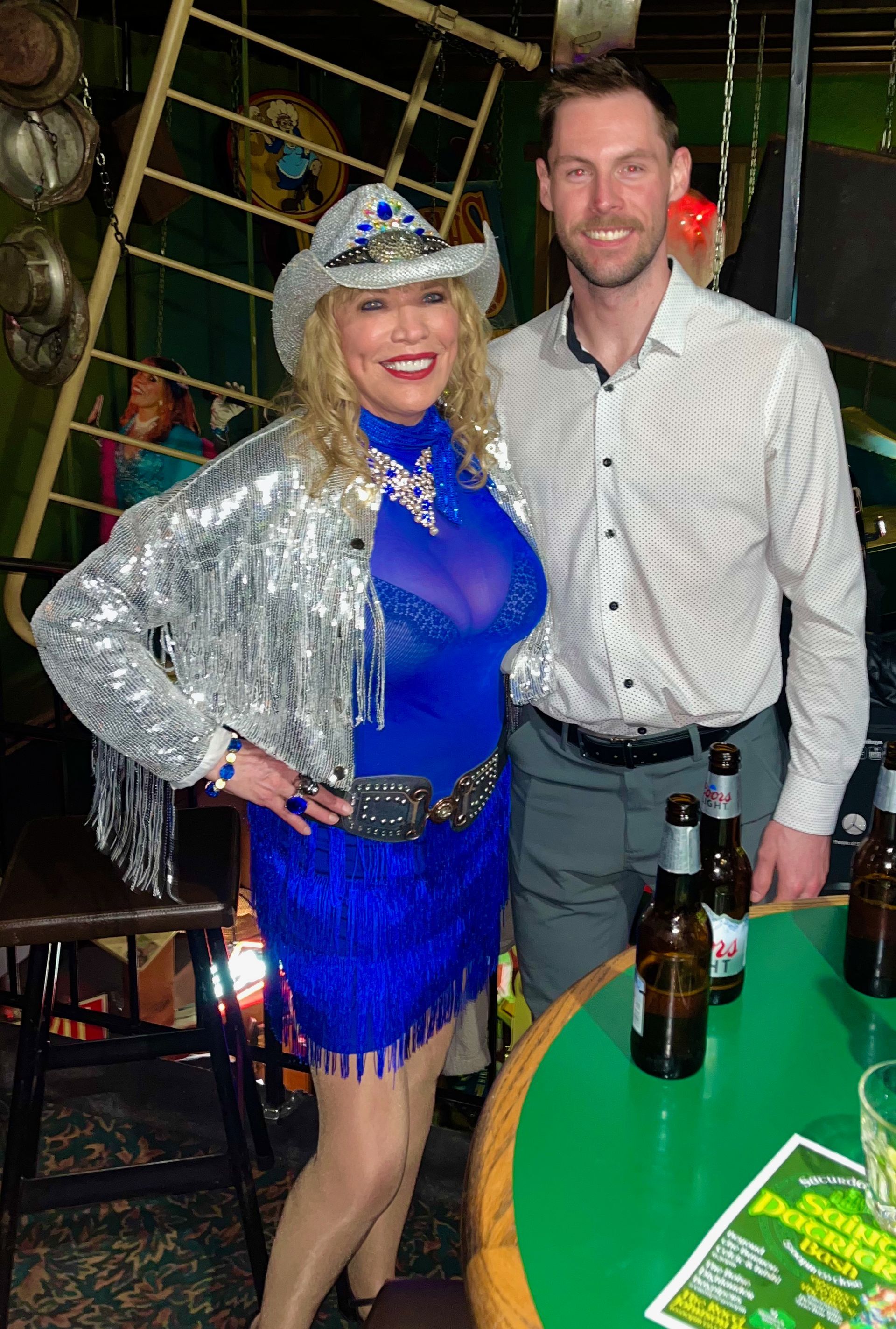 A man and a woman are posing for a picture in a bar.