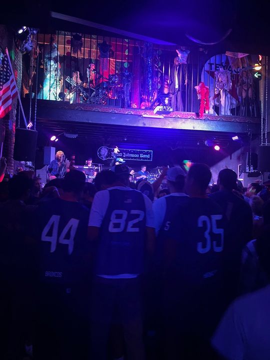 A group of people standing in front of a stage wearing jerseys with the numbers 44 82 35