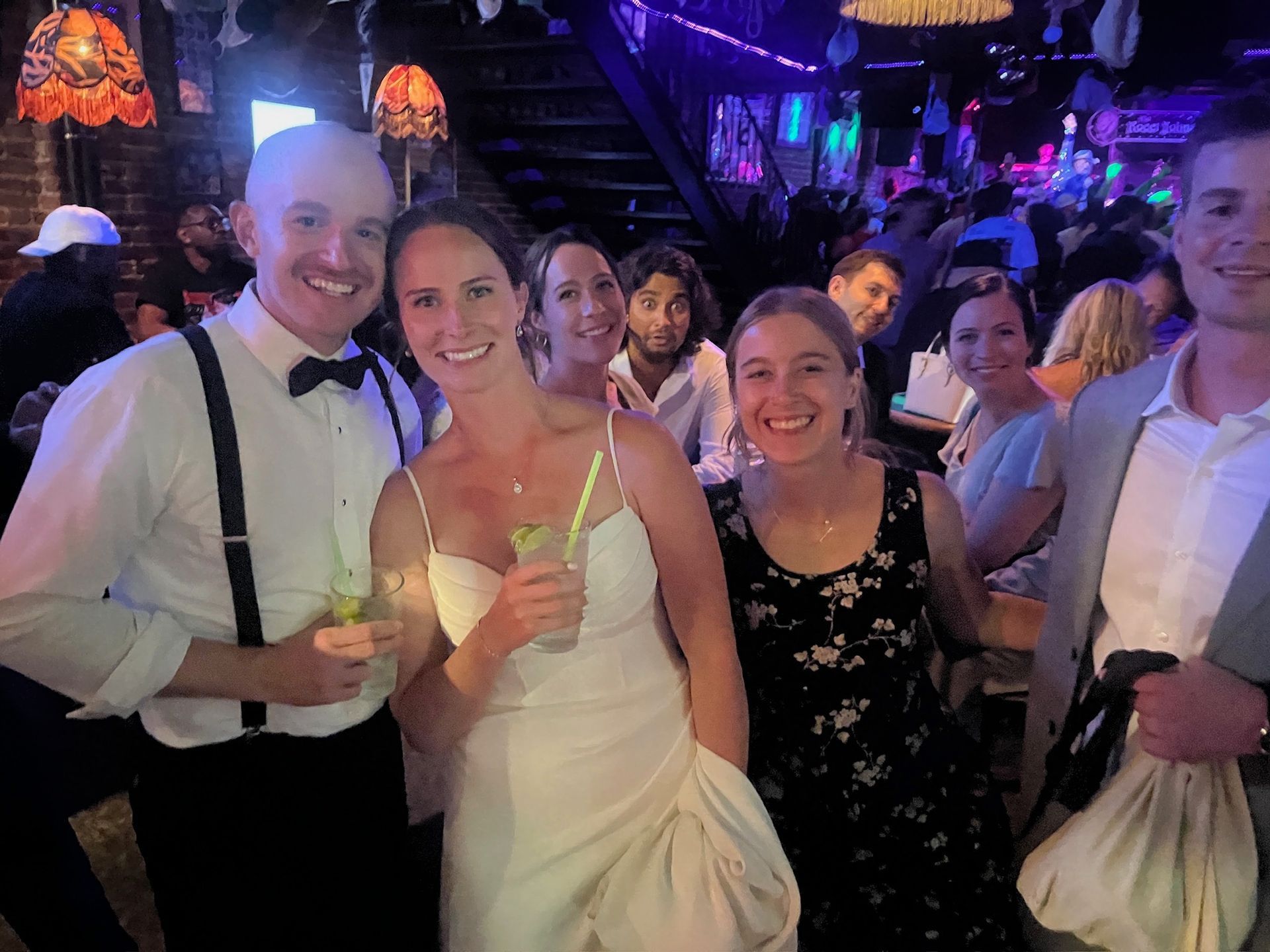 Three women in cowboy hats are sitting at a table in a bar.
