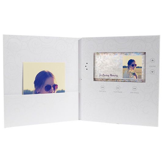 Open white photo book displaying a portrait on the left and a small screen preview on the right