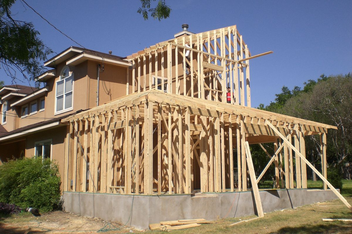 House under construction; wooden frame addition with visible studs.