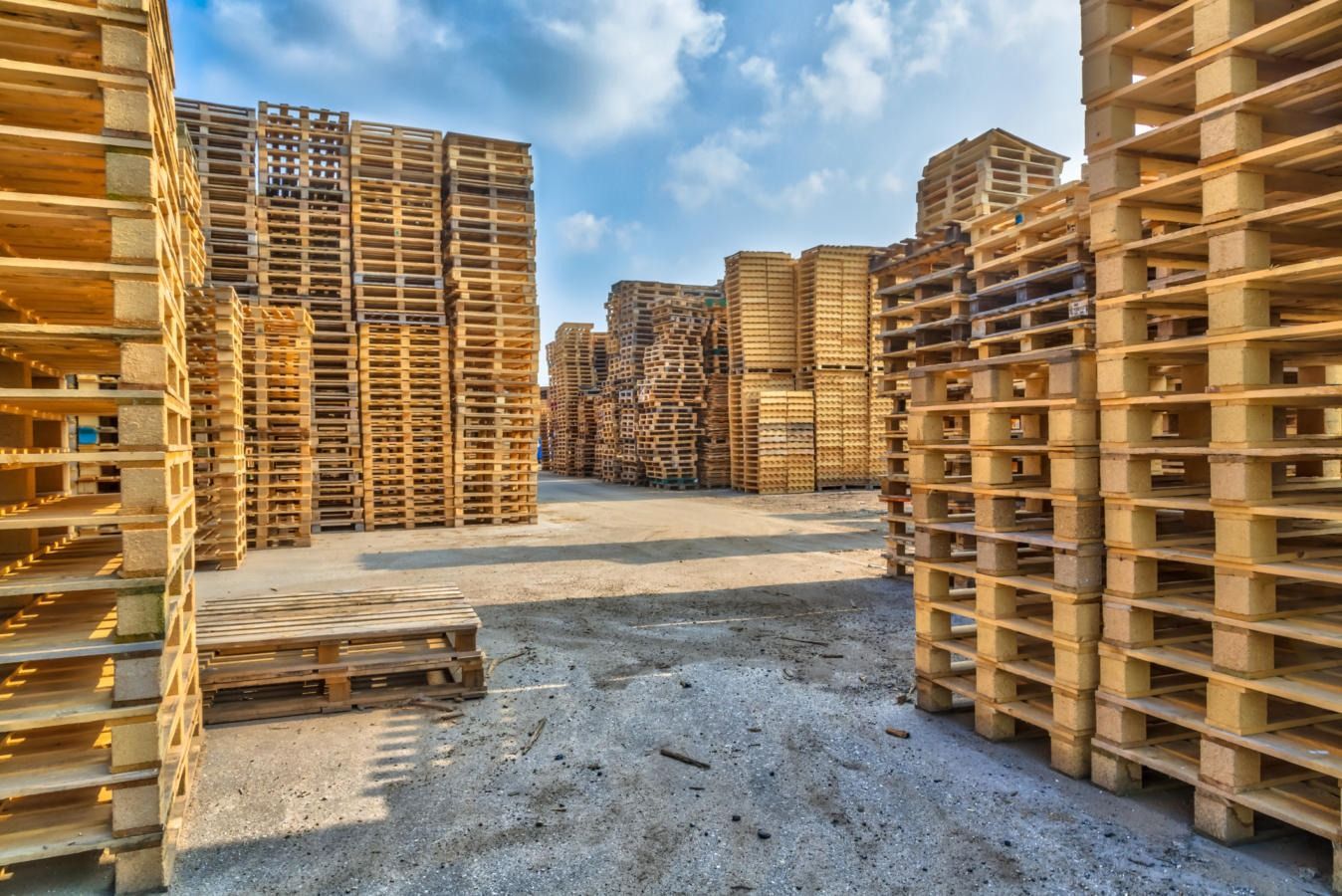 A warehouse filled with lots of wooden pallets stacked on top of each other.