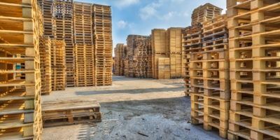 A warehouse filled with lots of wooden pallets stacked on top of each other.