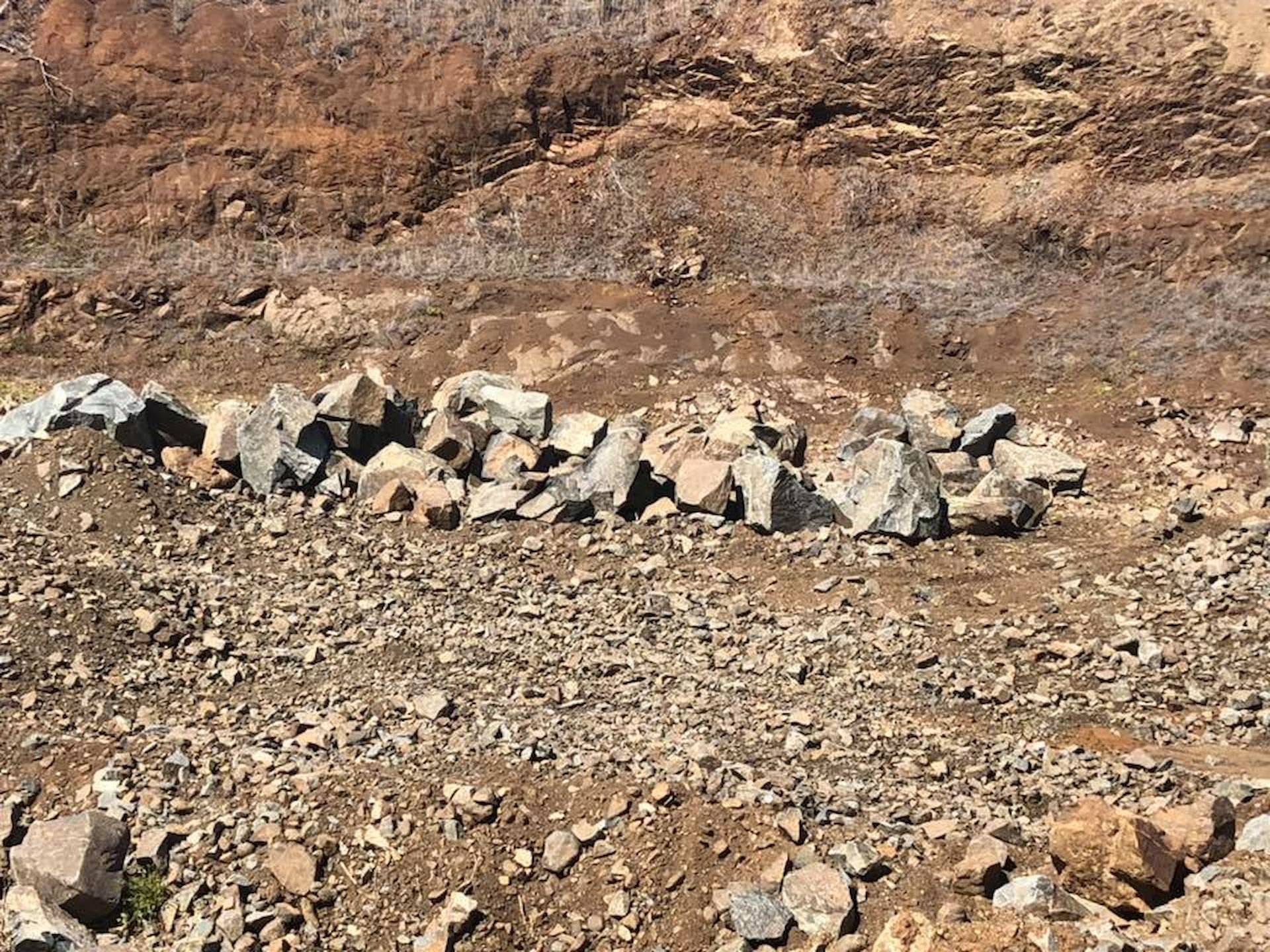 Rocks Arranged in a Line on a Dirt Ground in Front of a Layered — The Caves Quarry CQ in The Caves, QLD