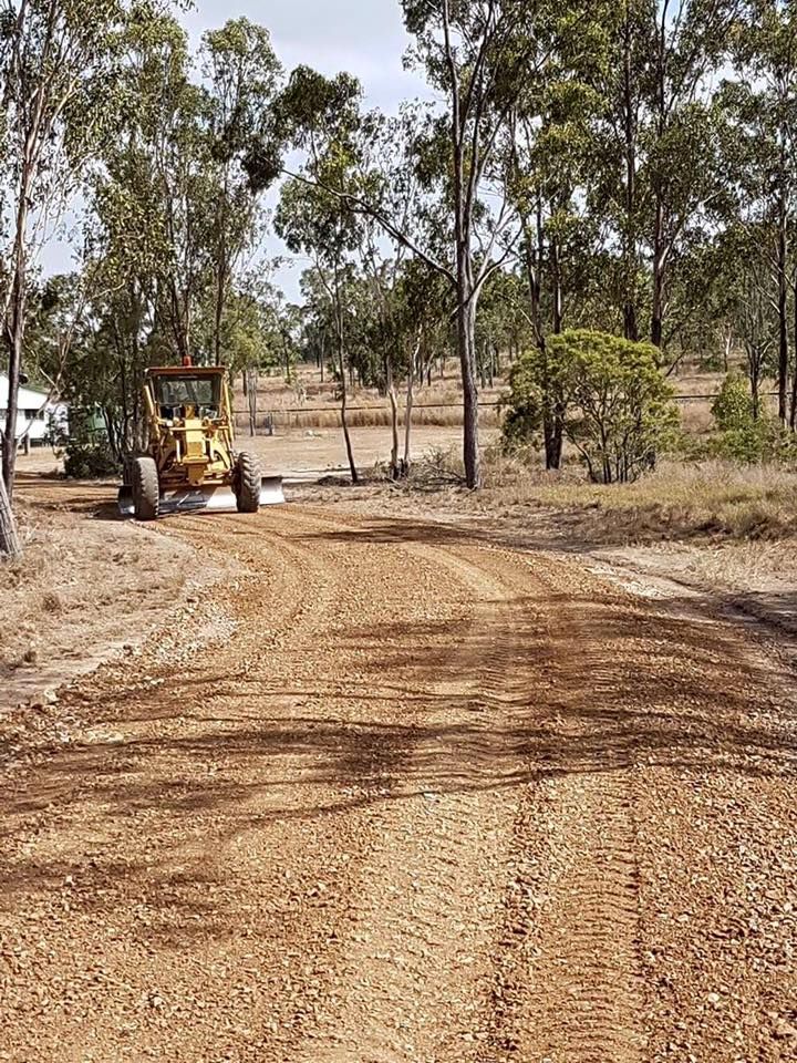A Dirt Road Being Graded by a Yellow Tractor-grader in a Forest Clearing — The Caves Quarry CQ in The Caves, QLD