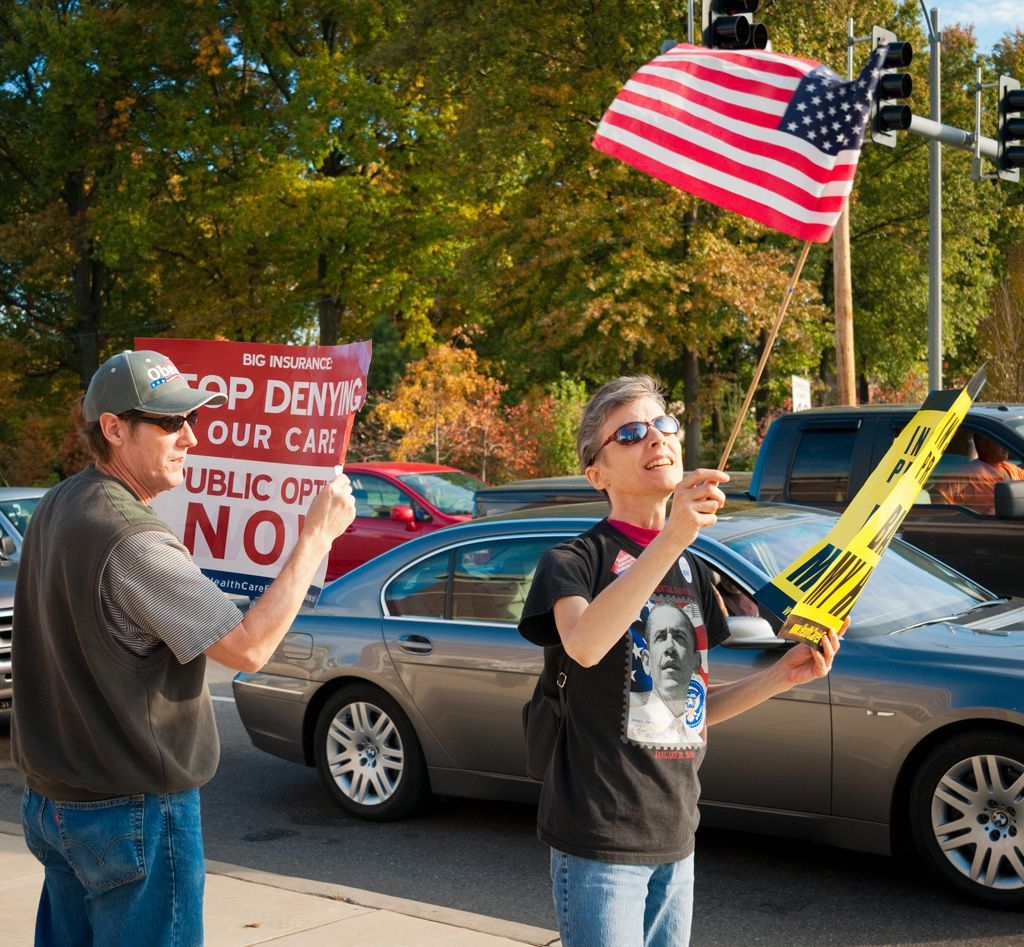 One of the first Affordable Care Act demonstrations in St. Louis, Missouri was held at the corner of Skinker Boulevard and Forest Park Parkway where Kayak’s Coffee (now a Kaldi’s) resided. The young woman (right) in this photo is Melanie Shouse, an early healthcare activist. Melanie died on January 30, 2010 after a long battle with breast cancer. She had been a foot soldier for Obama and healthcare reform. The lack of affordable healthcare insurance was personal to Melanie. She said in an interview on KDHX radio, “I was only able to afford catastrophic health insurance coverage with about $8,000 in co-pays and deductibles,” Ms. Shouse said. “As a result, I put off getting preventive services and medical screenings and treatments.” Photographed October 20, 2009.