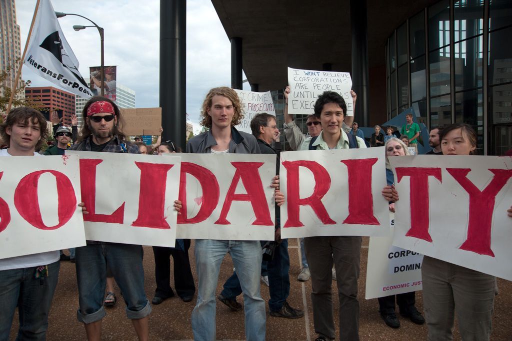 Not unlike today, the gap between the rich and the poor in the United States was widening at a frantic pace. Inequity between the classes created hardships for many Americans from healthcare costs to housing, even putting food on the table. For a few, times were great, but for most it was scary and harmful. The chant of “One Percent” identified those privileged few who were oppressing the “rest of us” and caused protests to mount. This group of students said it all with their banner about how to fight the oppression, and they stood proudly just outside the doors of then Boatmen’s Bank in downtown St. Louis. Photographed October 18, 2011. 