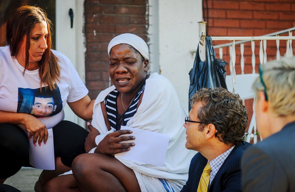 The tenant of an apartment with only an hour’s notice was threatened with eviction. She is being consoled here by two attorneys (Thomas Harvey, left, and Lee Camp, right; and an unidentified woman outside of her apartment while waiting to hear back from the landlord’s attorney. Photographed on August 4, 2017. 