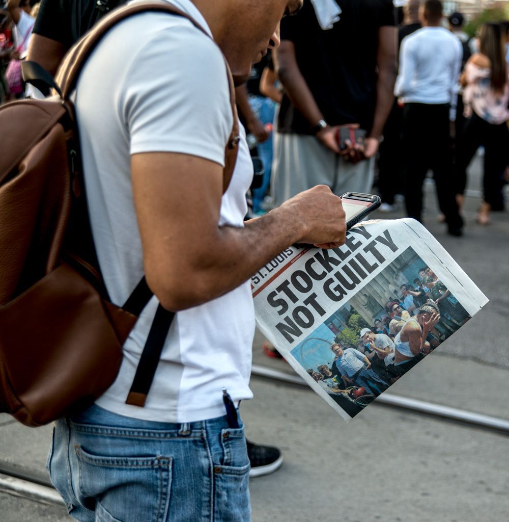 A demonstrator, prior to a protest march, holds a copy of the day’s St. Louis Post-Dispatch newspaper with a headline that sounded the alarm for that day’s action. Hundreds of protesters showed up of all ages, races, varied socioeconomic backgrounds, and education to have their voices heard about their shock at the trial results. Photographed on September 16, 2017. 