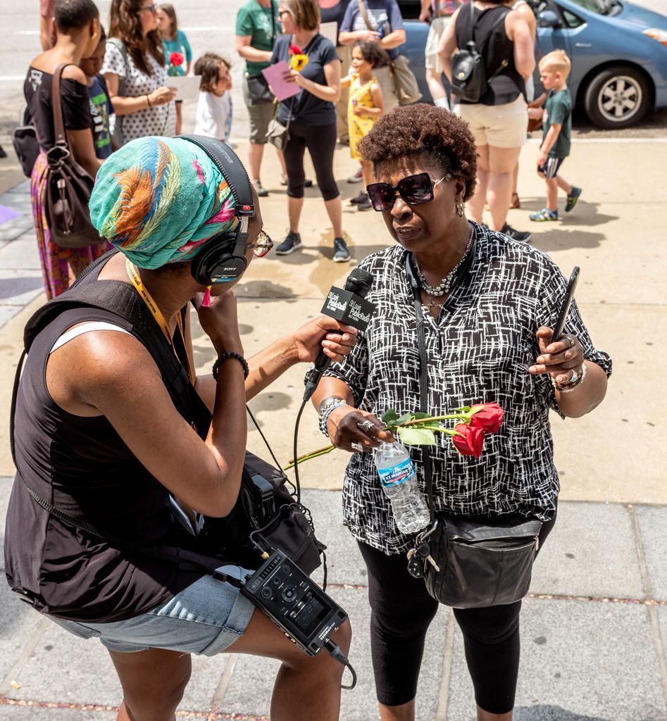 A spouse of one inmate speaks to a St. Louis Public Radio (NPR) reporter to explain the effects of high cost bail to poor families. First, many cannot afford the bail. Being in jail for months awaiting trial puts them into further risks. By not being able to go to work, they risk losing their jobs, or while not working, cannot pay rent and risk eviction. They also face having utilities turned off for lack of payment, and some even have fallen ill because of lack of medical attention and prescriptions while incarcerated, just to name a few possibilities in this inequitable system. Photographed on May 12, 2018.