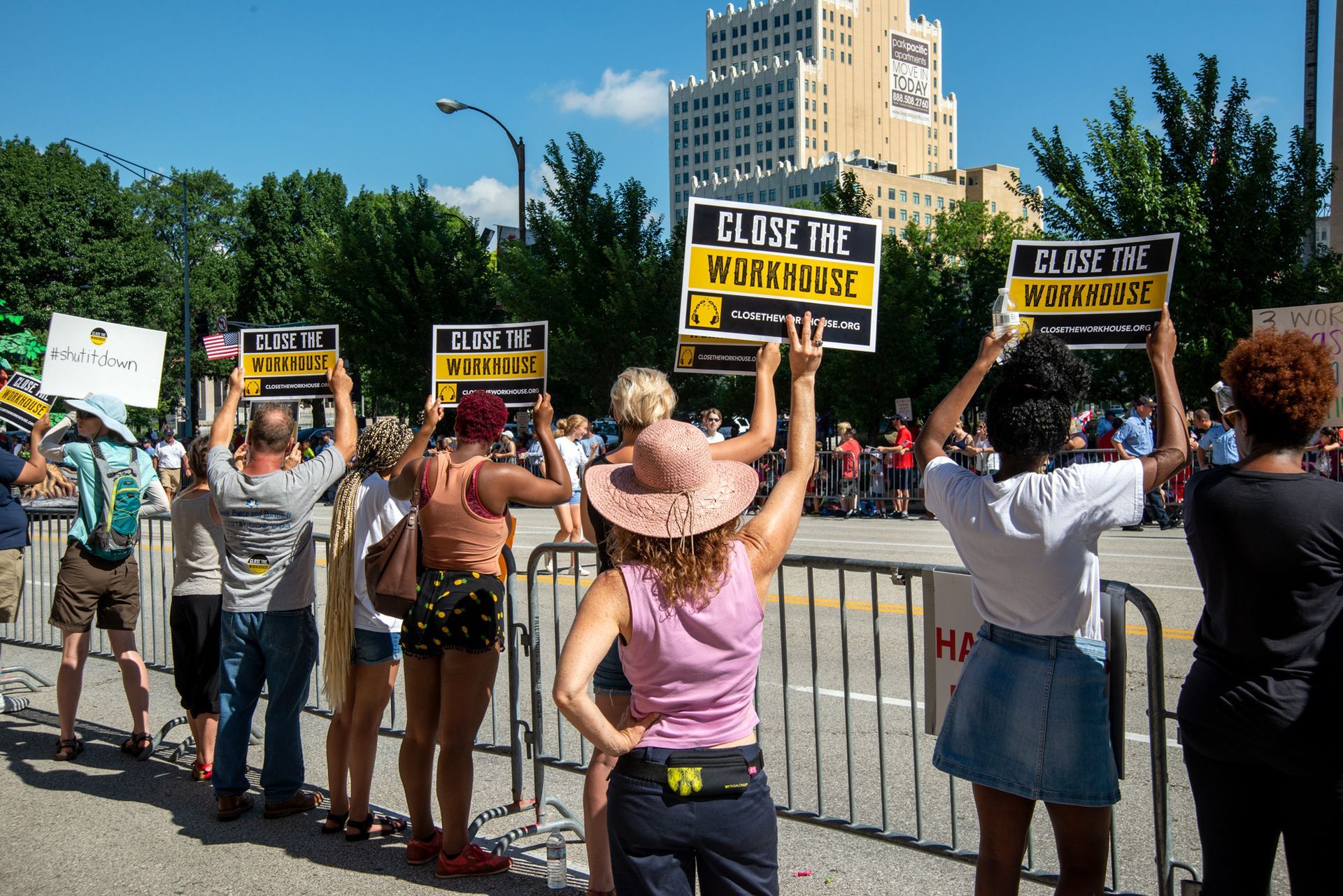 Here protesters face the July 4th parade with signs that inform City residents on Independence Day that the St. Louis Workhouse still exists and should be closed. Public outcry eventually closed the Workhouse after a three-year campaign and public opinion changed after the horrific conditions there such as extreme heat and cold, abysmal medical care, rats and cockroach infestations and mold became known. Organizations like ArchCity Defenders, Action St. Louis, and The Bail Project were instrumental in closing the derelict jail, and recently it was demolished. Photographed on July 4, 2014.