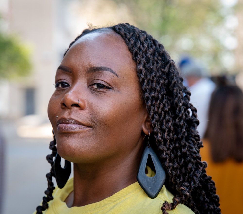 this African American  woman is wearing a yellow shirt and black earrings, Inez Bordeaux, staff person at ArchCity Defenders, a non-profit civil rights law firm in St. Louis, Missouri.