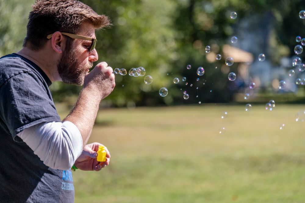Nathaniel Carroll, attorney for ArchCity Defenders, a non-profit civil rights law firm in St. Louis, Missouri, blows soap bubbles in a park during the firm's annual community appreciation picnic.