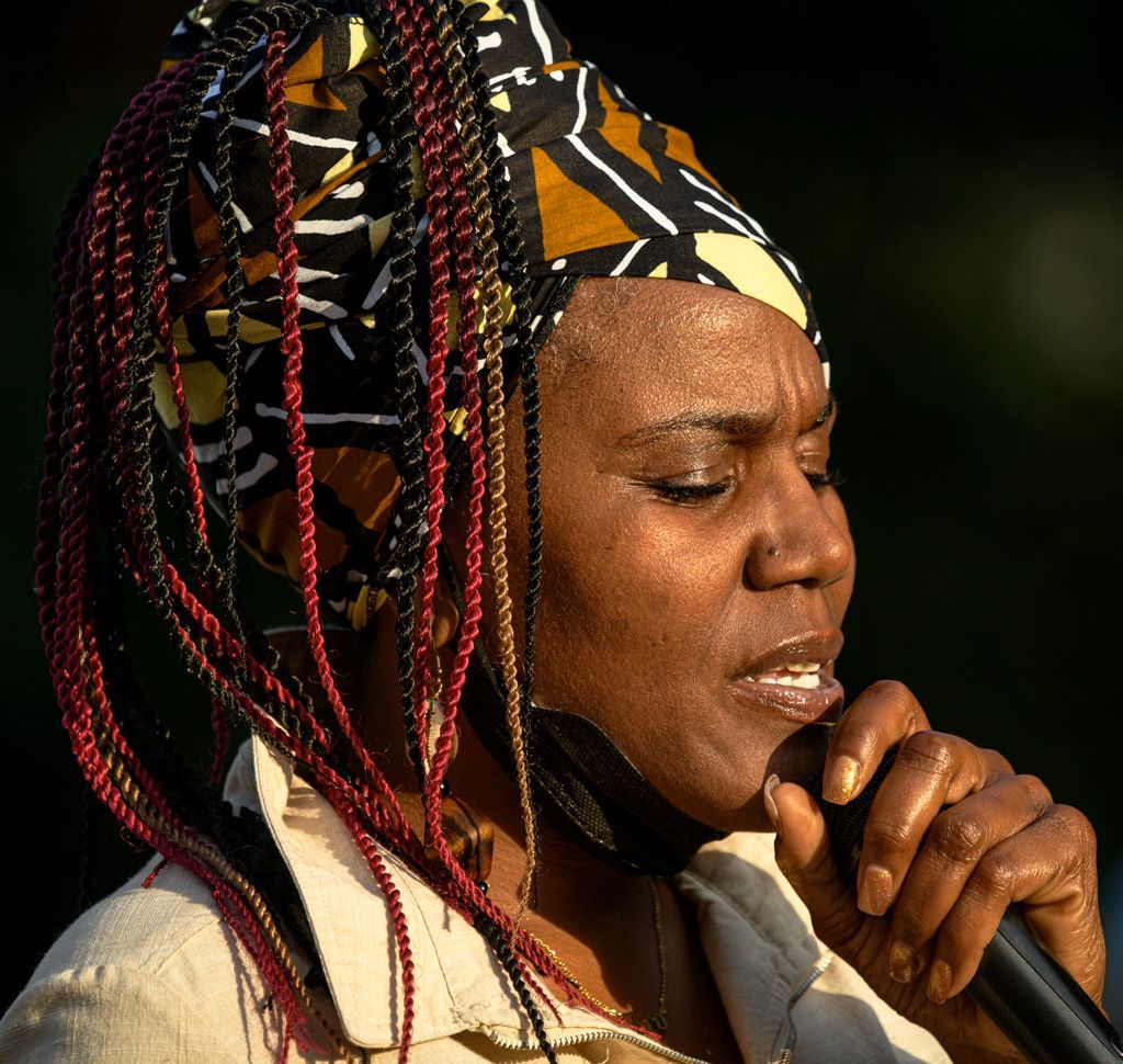 At a vigil in Kiener Plaza in downtown St. Louis: This unidentified woman led a prayer for Sonya Massey, a 36-year-old unarmed Black woman who was murdered by a white sheriff’s deputy in Sangamon County, Illinois (near Springfield). She had called 911 about a possible prowler. She was shot and killed by the officer as she stood at her stove holding a pot of hot water. He cited “fear for his life” to justify the use of lethal force. The officer was eventually found guilty of second-degree murder. Photographed on July 29, 2024. 