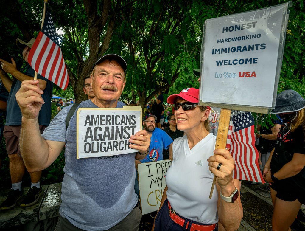 Signs convey beliefs for protesters and display their priorities. This couple stood for hours in the heat to make their grievances known under their First Amendment rights during the “No Kings” protest in Kiener Plaza, downtown St. Louis, Missouri. Photographed on June 14, 2025.