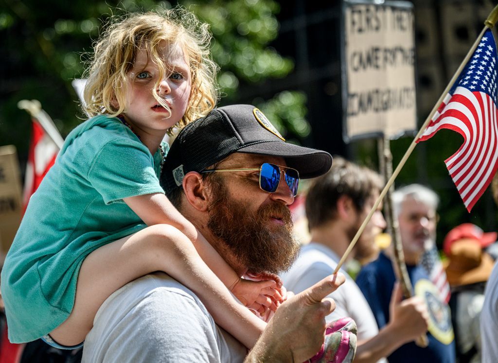 On the long march from Kiener Plaza around the perimeters of downtown St. Louis, this father gave a piggyback ride to his daughter, giving a valuable civics lesson to her at the same time. Children and pets were active participants of this “No Kings” protest in St. Louis, Missouri along with college students, retirees, veterans, feminists, people of color and varied national origins. It was a true melting pot day. Photographed on June 14, 2025.