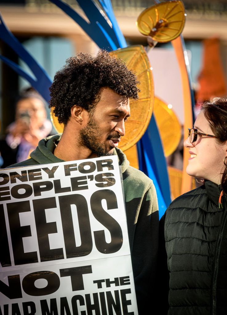 A couple stands in protest of where taxpayer dollars are being spent to militarize American communities where ICE roams and randomly abducts people based on skin color and accents, all while also detaining and arresting American citizens for no apparent reasons without court-ordered warrants or due process. The commitment that couples, families, neighbors and others make to each other strengthen the resistance to the tyranny and authoritarianism America witnesses these days. Photographed January 11, 2026.