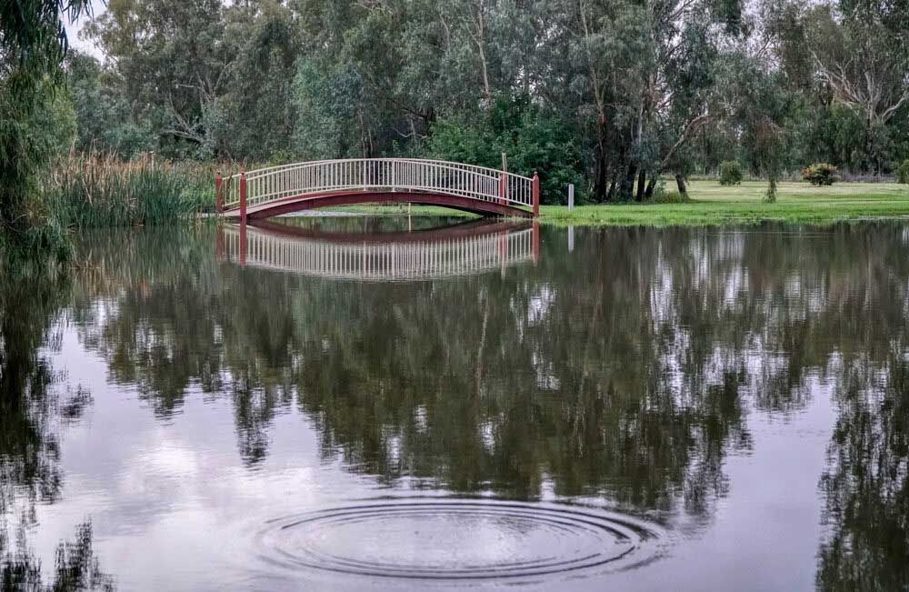 A Red Bridge Is Floating In The Middle Of A Lake — Mid Coast Boundary Fencing In Smiths Lake, NSW