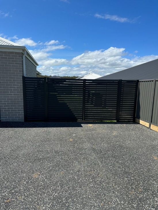 A Black Fence Is In The Middle Of A Grassy Field — Mid Coast Boundary Fencing In Harrington, NSW