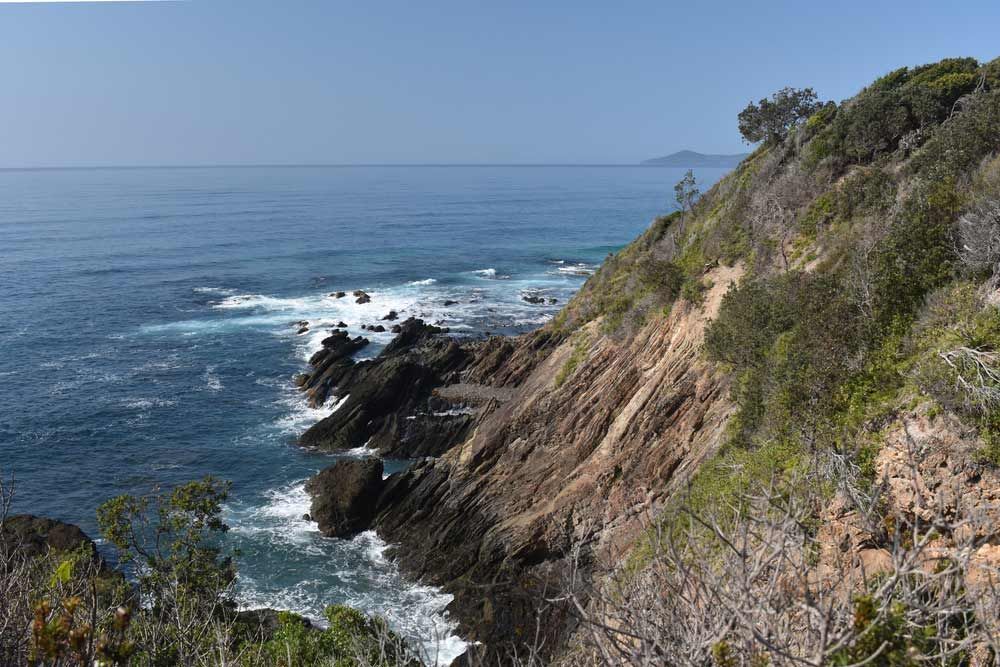 A Cliff Overlooking The Ocean With Waves Crashing On The Rocks — Mid Coast Boundary Fencing In Forster, NSW