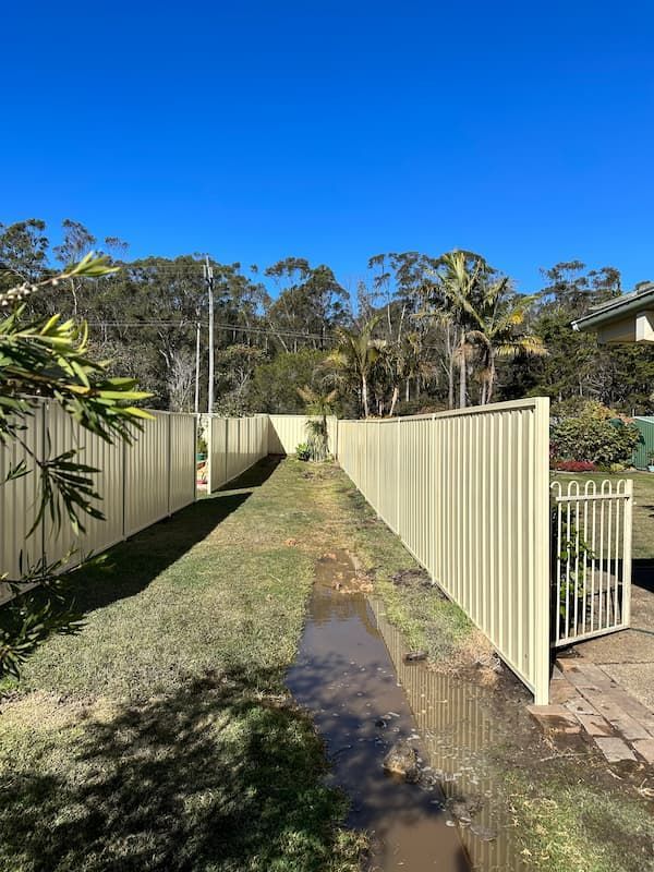 A White Fence Surrounds A Muddy Path In A Backyard — Mid Coast Boundary Fencing In Old Bar, NSW