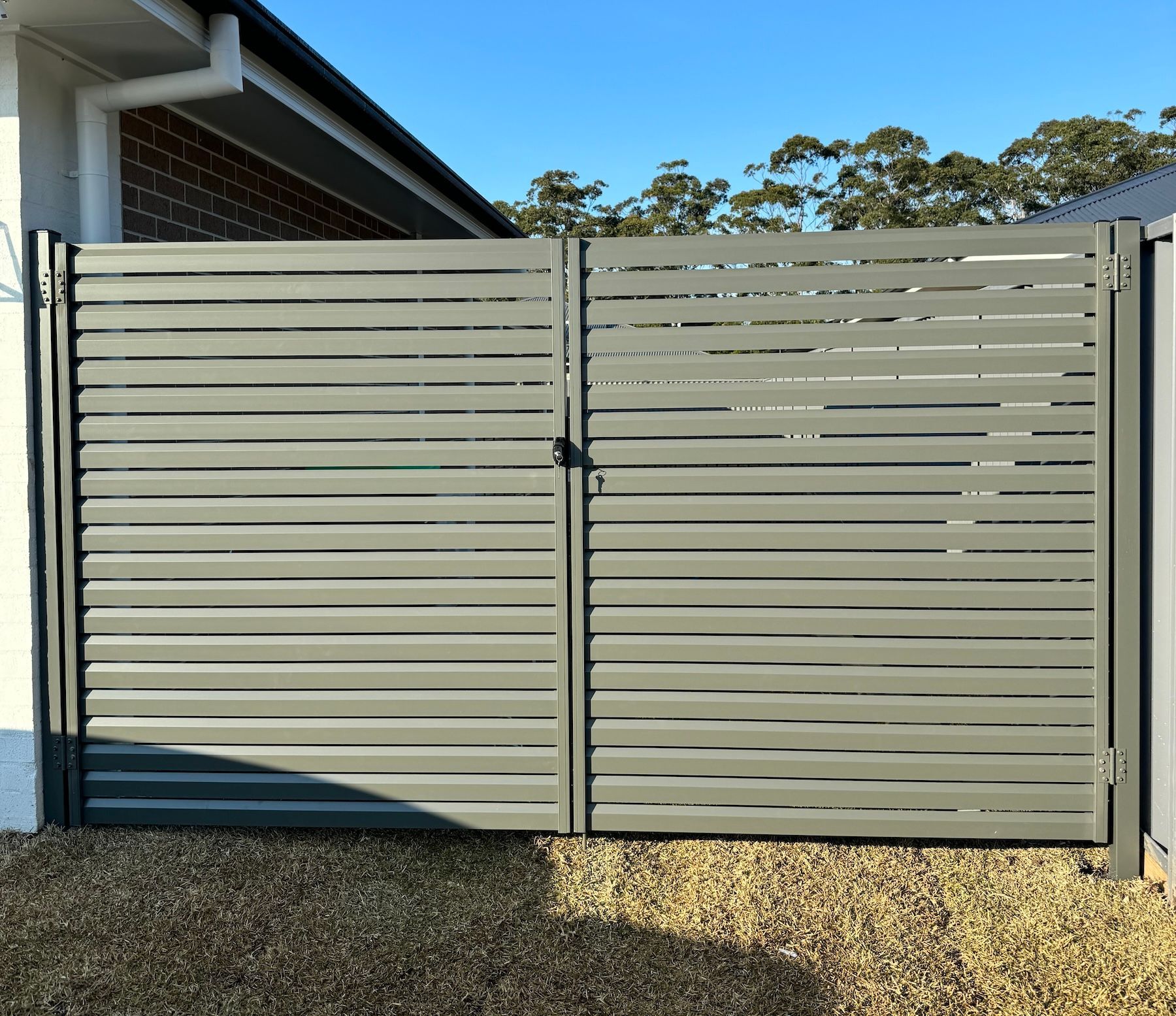 A Fence Is Surrounding A Grassy Field With A House In The Background — Mid Coast Boundary Fencing In Harrington, NSW