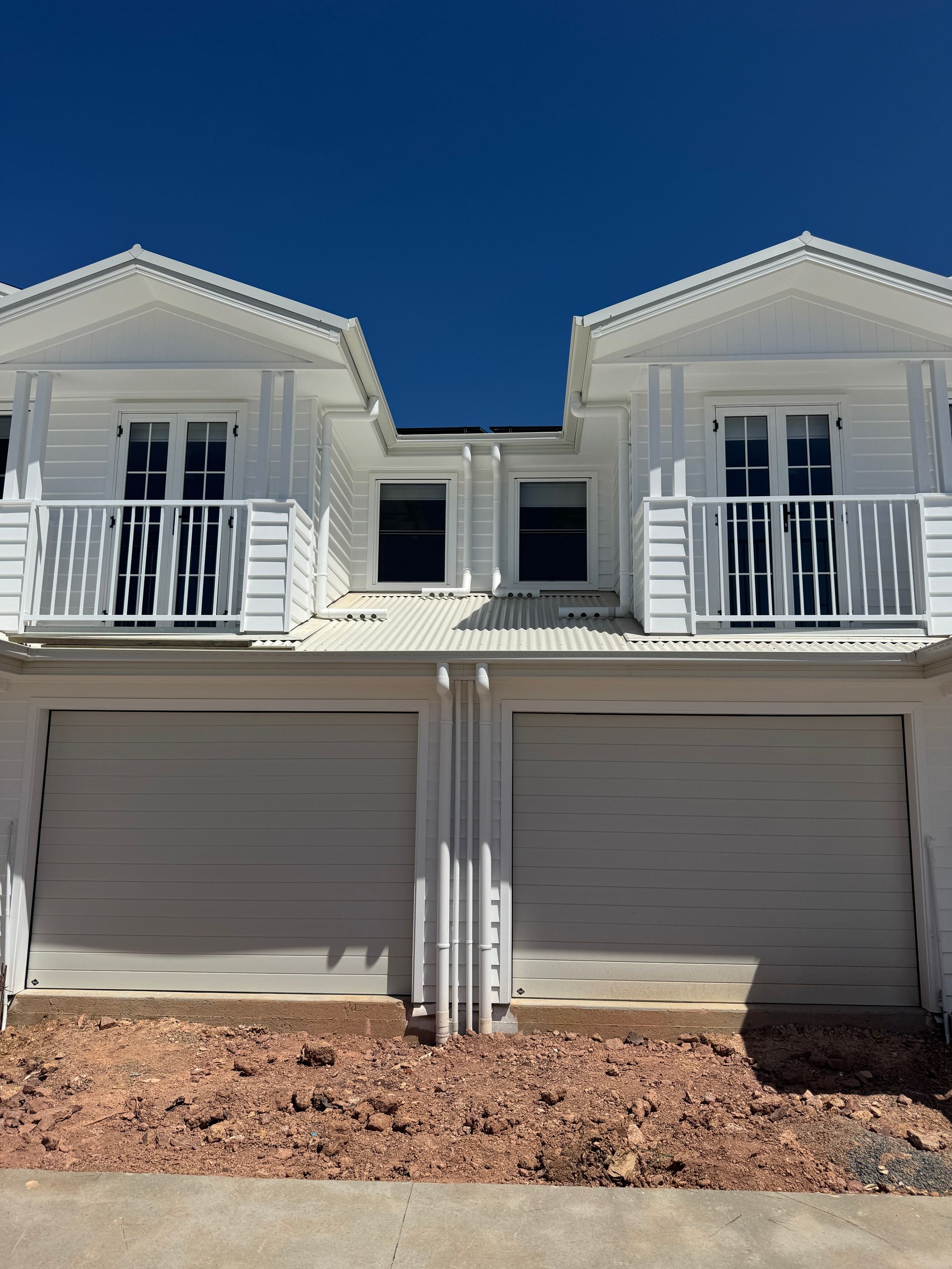 A White Gate Is Sitting Next To A Brick Wall — Mid Coast Boundary Fencing In Old Bar, NSW