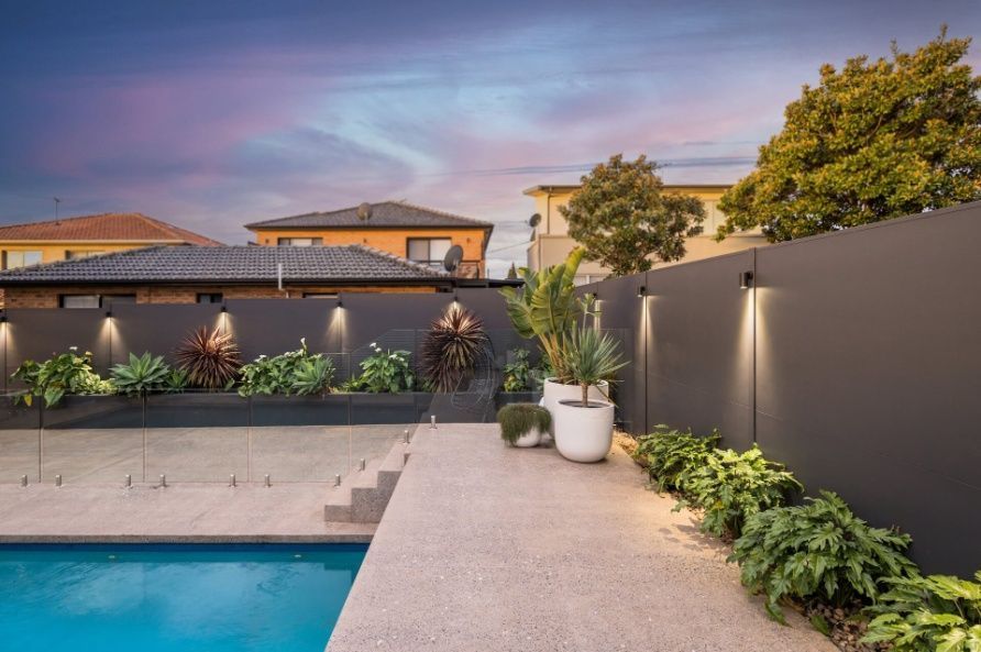 There Is A Swimming Pool In The Backyard Of A House — Mid Coast Boundary Fencing In Taree, NSW