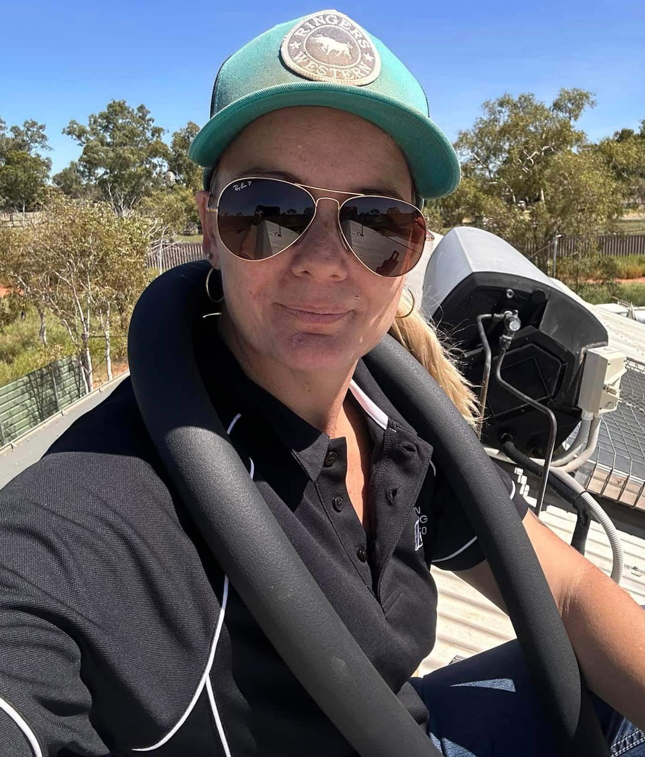 A Woman Wearing Sunglasses And A Hat Is Taking A Selfie — Araluen Plumbing In Braitling, NT