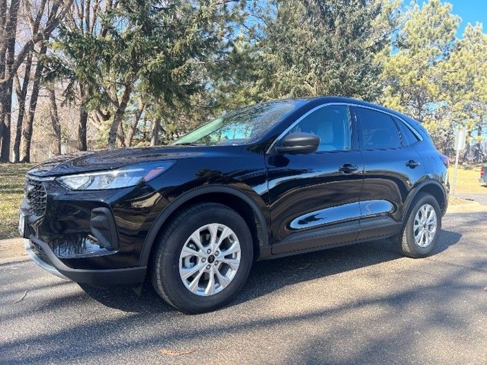A White Suv is Driving Down a Road with Trees in the Background | Rochester and Austin, MN | Kuehn Rental