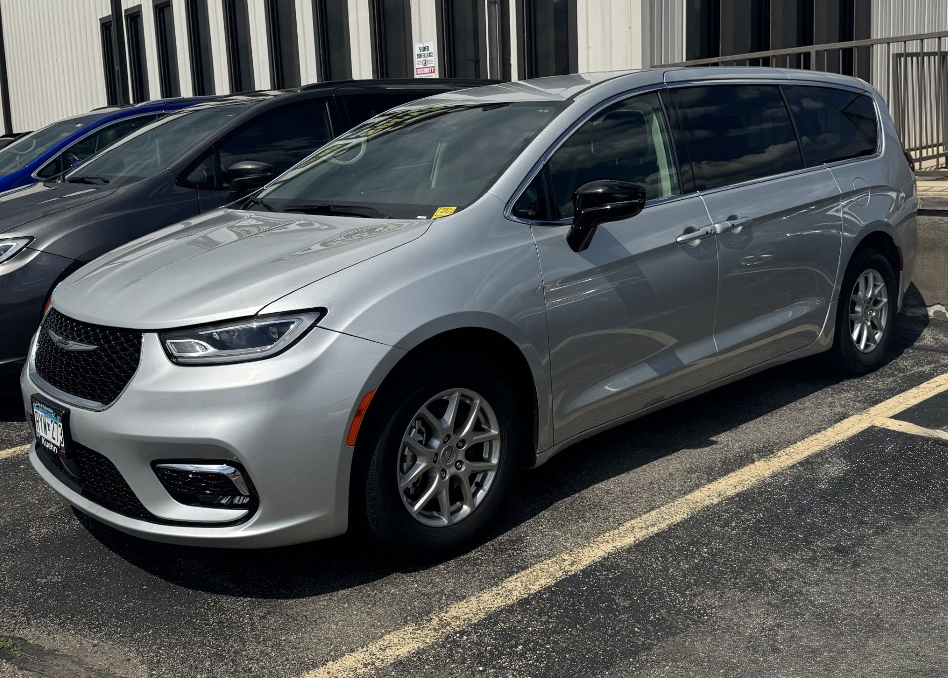 Three black vans are parked next to each other in a parking lot.