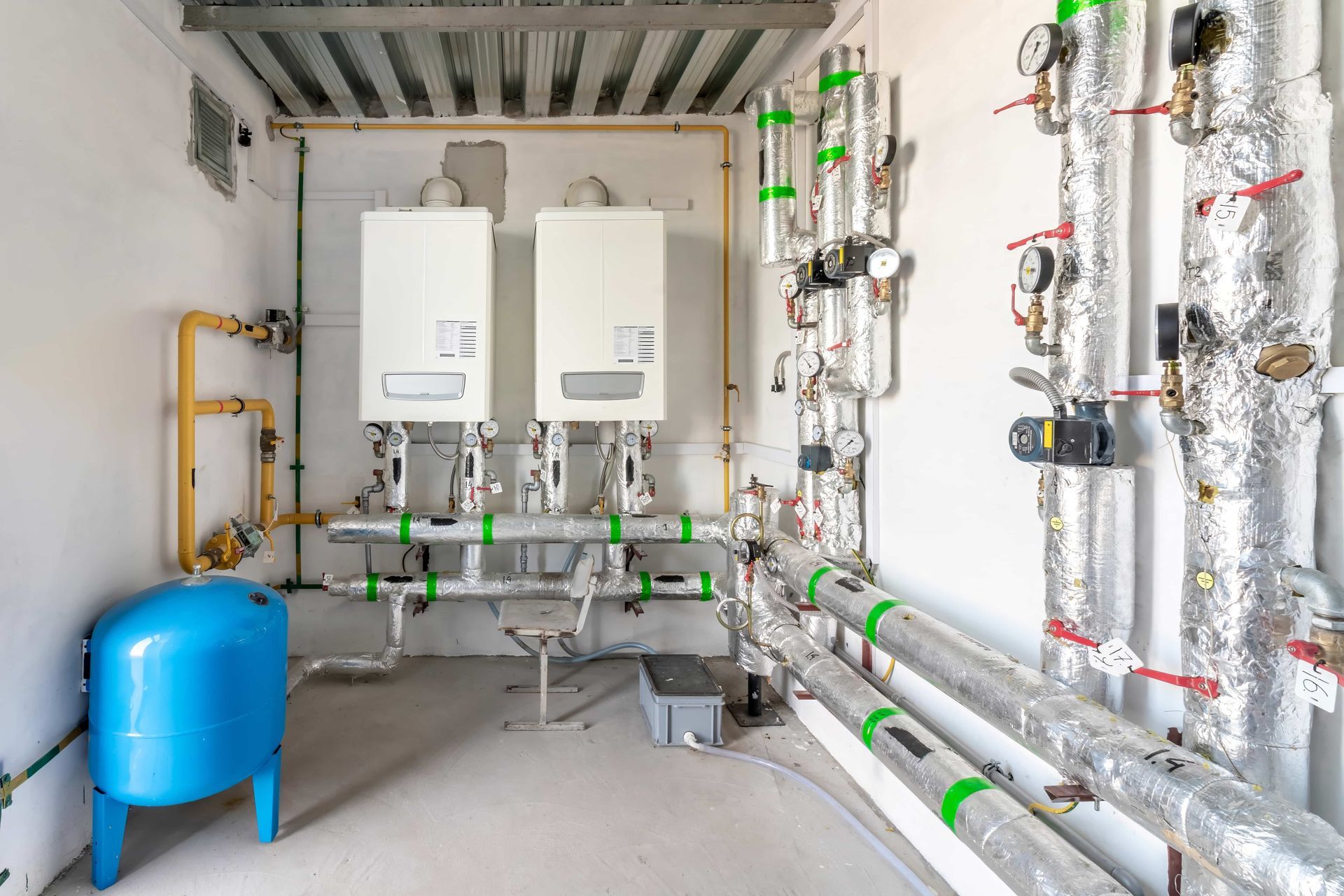 A room filled with lots of pipes and boilers.