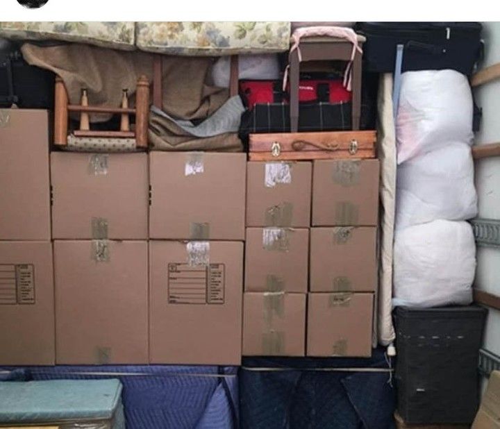 Truck interior packed with boxes, furniture, and bags during a move.