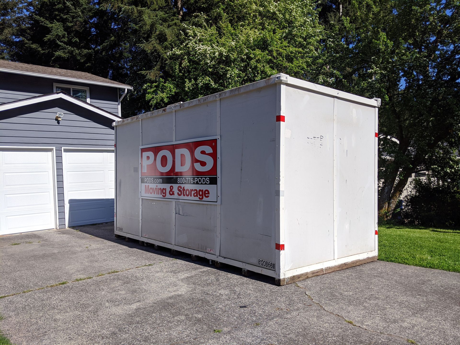 Cluttered room with stacked cardboard boxes, baskets, and miscellaneous items near a window.