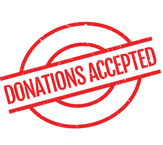 Dancers in motion in a studio. Arms outstretched, mid-air leap. Wooden floor, other dancers blurred in background.