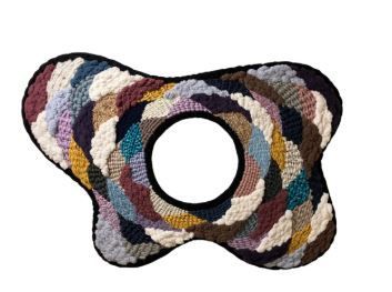 White buildings with red roofs on a grassy hill under a blue sky.