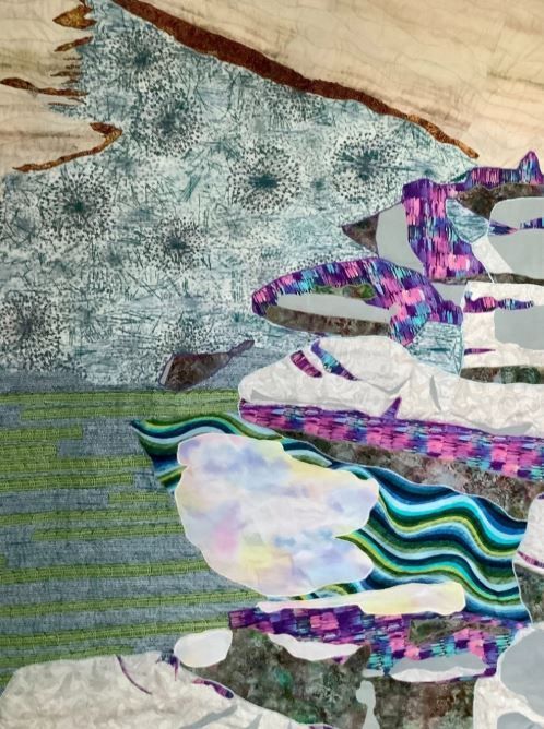 White buildings with red roofs on a grassy hill under a blue sky.