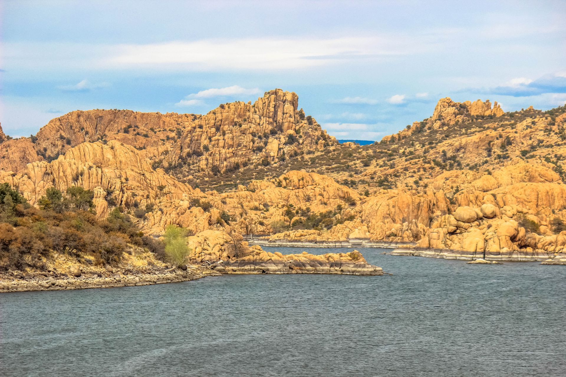 A lake with mountains in the background and a small island in the middle.