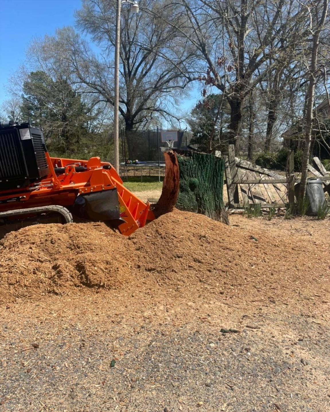 A bulldozer is working on a pile of wood chips.