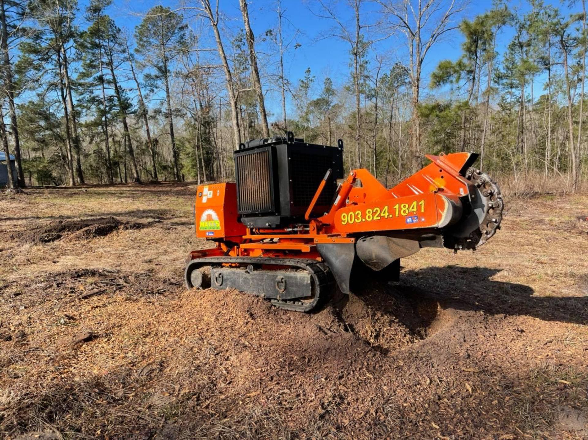 A stump grinder is sitting in the middle of a field.