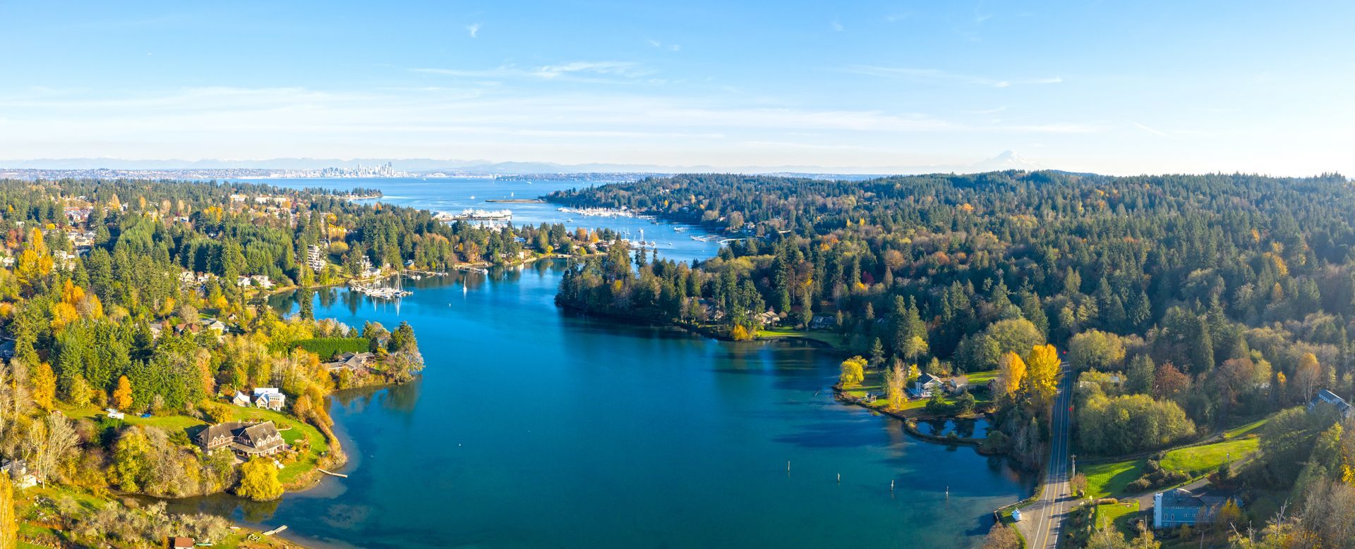 An aerial view of a bridge over a body of water with a city in the background.