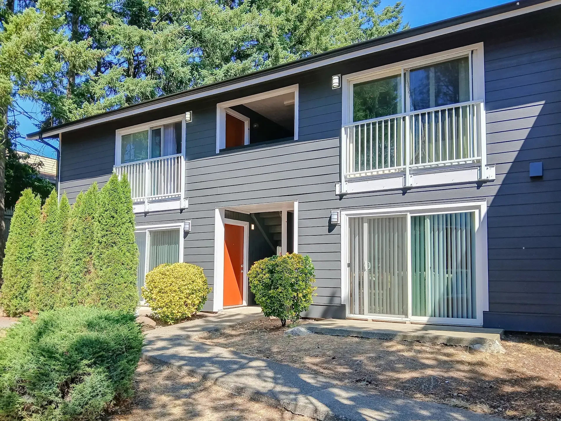 A ping pong table is sitting in front of a fence in a park.