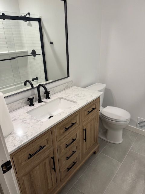 Beige house with porch, windows, and silver truck parked nearby on a sunny day.