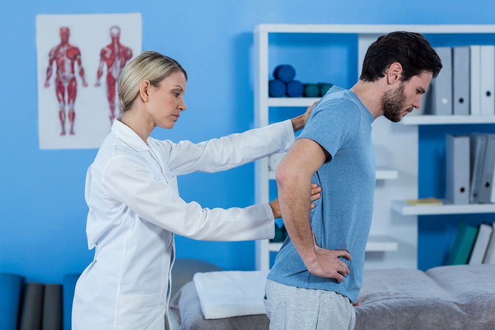 Physiotherapist Examining a Patient's Back at the Clinic — Physiotherapist in Bundaberg, QLD