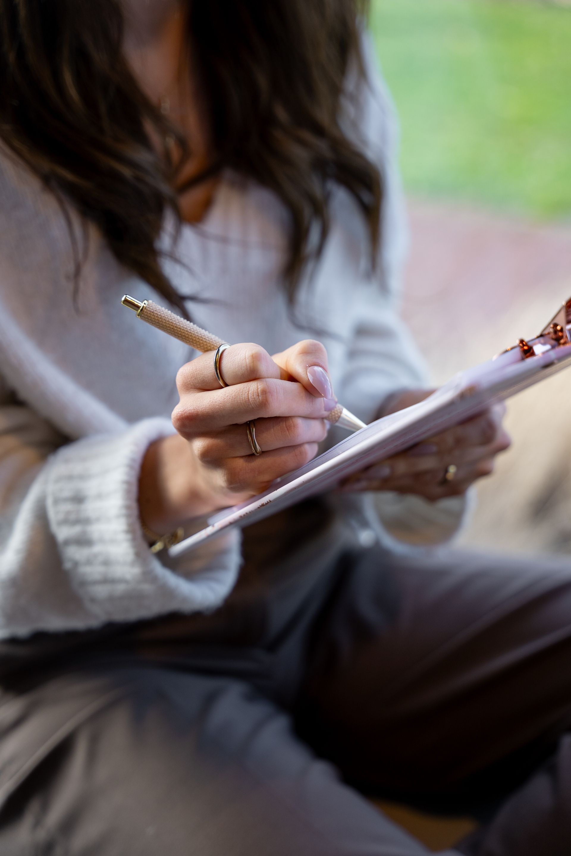 Een vrouw schrijft met een pen op een klembord.