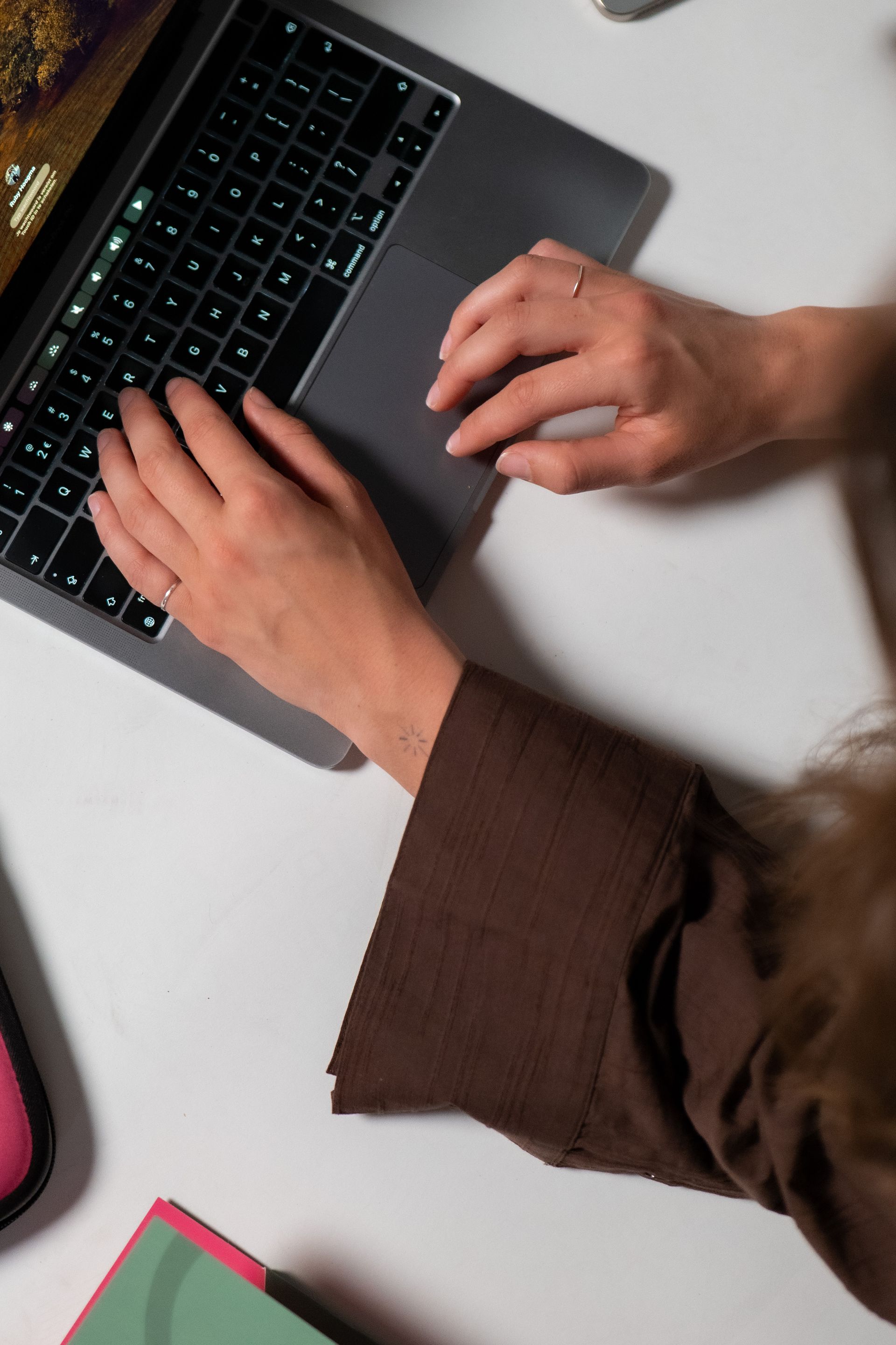 Drie vrouwen staan ​​naast elkaar en kijken naar een mobiele telefoon.